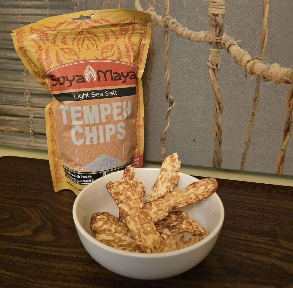 “A package of Soya Maya tangy garlic tempeh chips, showcasing a healthy alternative to salted tempeh crisps on a neutral background”.