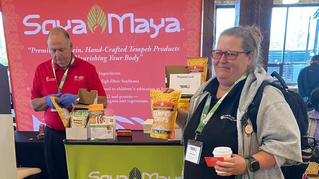 “Where can I find garlic tempeh chips Soya Maya booth at a food event, showcasing their tangy garlic tempeh chips and other hand-crafted tempeh products”.
