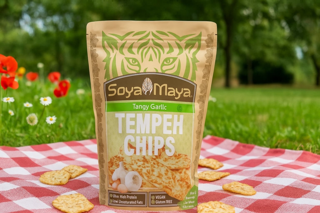 “where can I find garlic tempeh chips Soya Maya's tangy garlic tempeh chips, a vegan and high-protein snack option, displayed in a picturesque outdoor setting”.