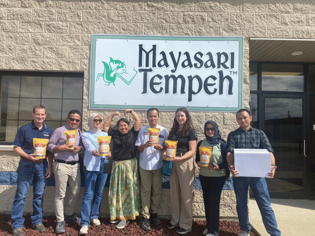 “What are tangy, this image does not appear to contain Soya Maya products. It shows a group of people holding Mayasari Tempeh products in front of a Mayasari Tempeh sign”.