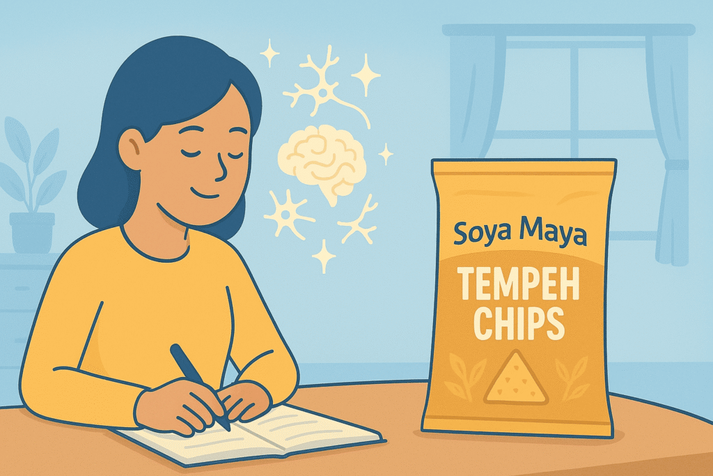 Woman writing with glowing brain illustration beside Soya Maya Tempeh Chips package promoting healthy eating and mental focus.