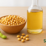 “Glass bottle of soybean oil with bowl of fresh soybeans.”