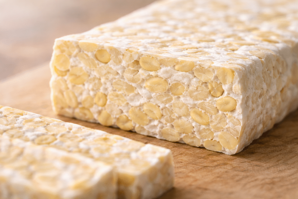 What is Artisanal Tempeh shown in close-up, highlighting dense white mycelium binding whole soybeans with a firm texture.