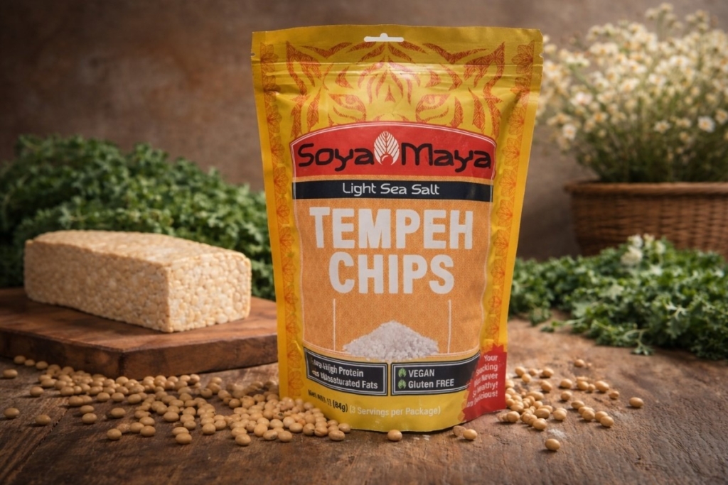 Packaged tempeh chips beside raw tempeh and soybeans, illustrating product options when deciding where to buy fresh tempeh