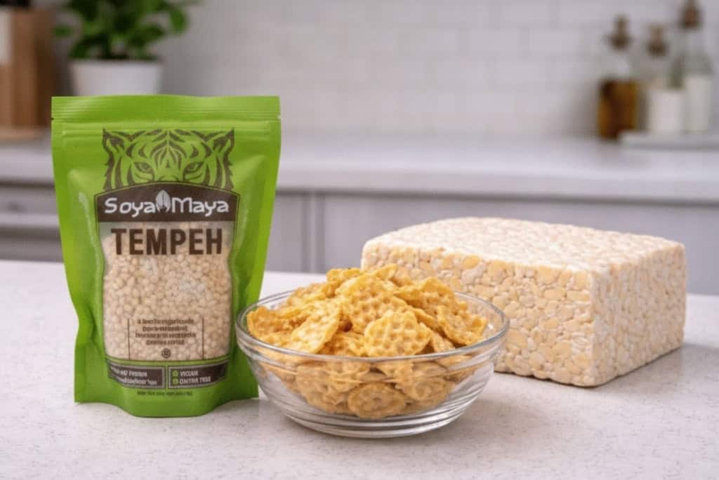 Soya Maya Tempeh package with fresh tempeh and soybeans on a kitchen countertop.