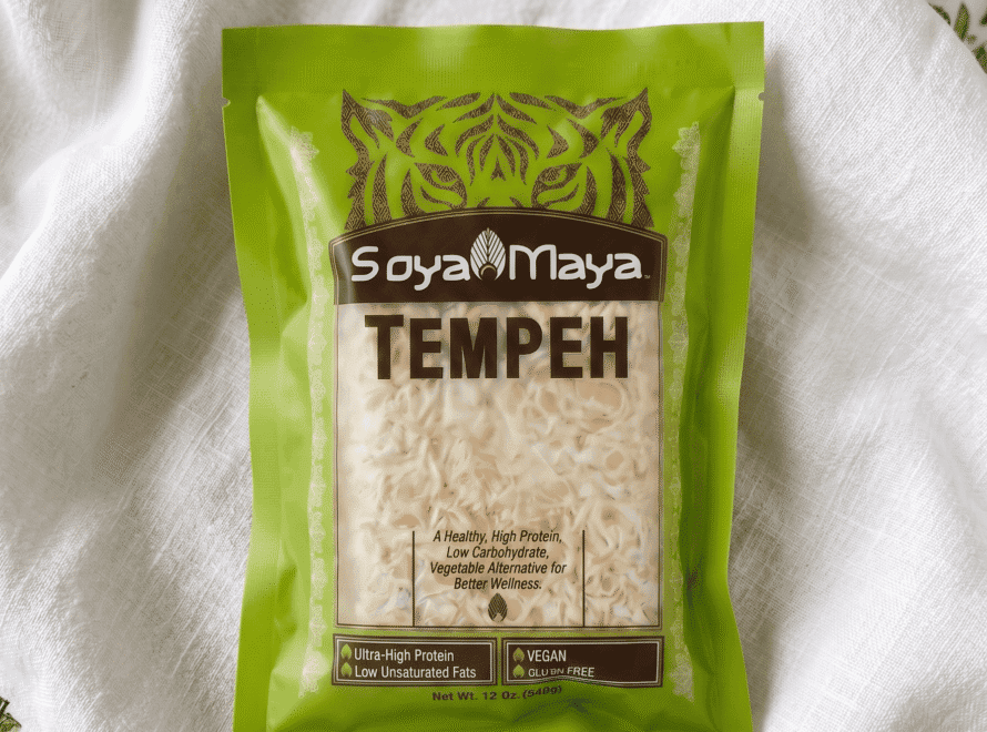 A green package of SoyaMaya Tempeh resting on a textured white cloth.