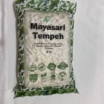 A 10oz vacuum-sealed bag of Mayasari Tempeh featuring a green leaf pattern and non-gmo certification labels.