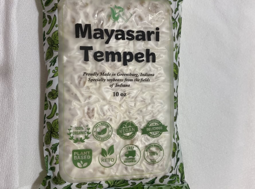 A 10oz vacuum-sealed bag of Mayasari Tempeh featuring a green leaf pattern and non-gmo certification labels.
