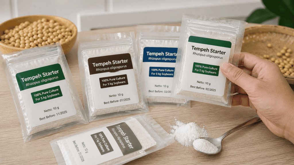 What is rhizopus oligosporus culture packets: multiple Tempeh Starter sachets beside soybeans and powder spilled on a spoon
